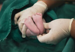 a newborn baby's feet being held by a doctor's gloved hands